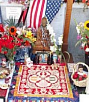This is a shot of the center of the memorial. An American flag. Below is a Buddhist statue, a carpet and praying cushion.