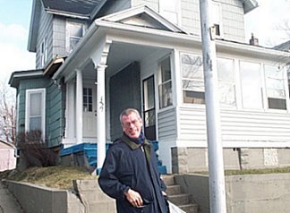 Steve standing in front of the two story wood frame house.