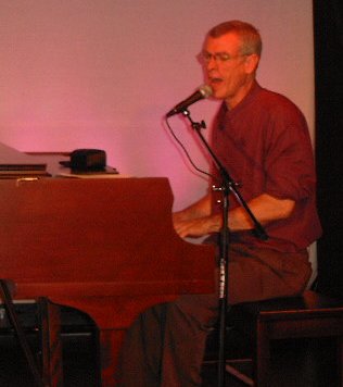 Steve Schalchlin singing at the piano.